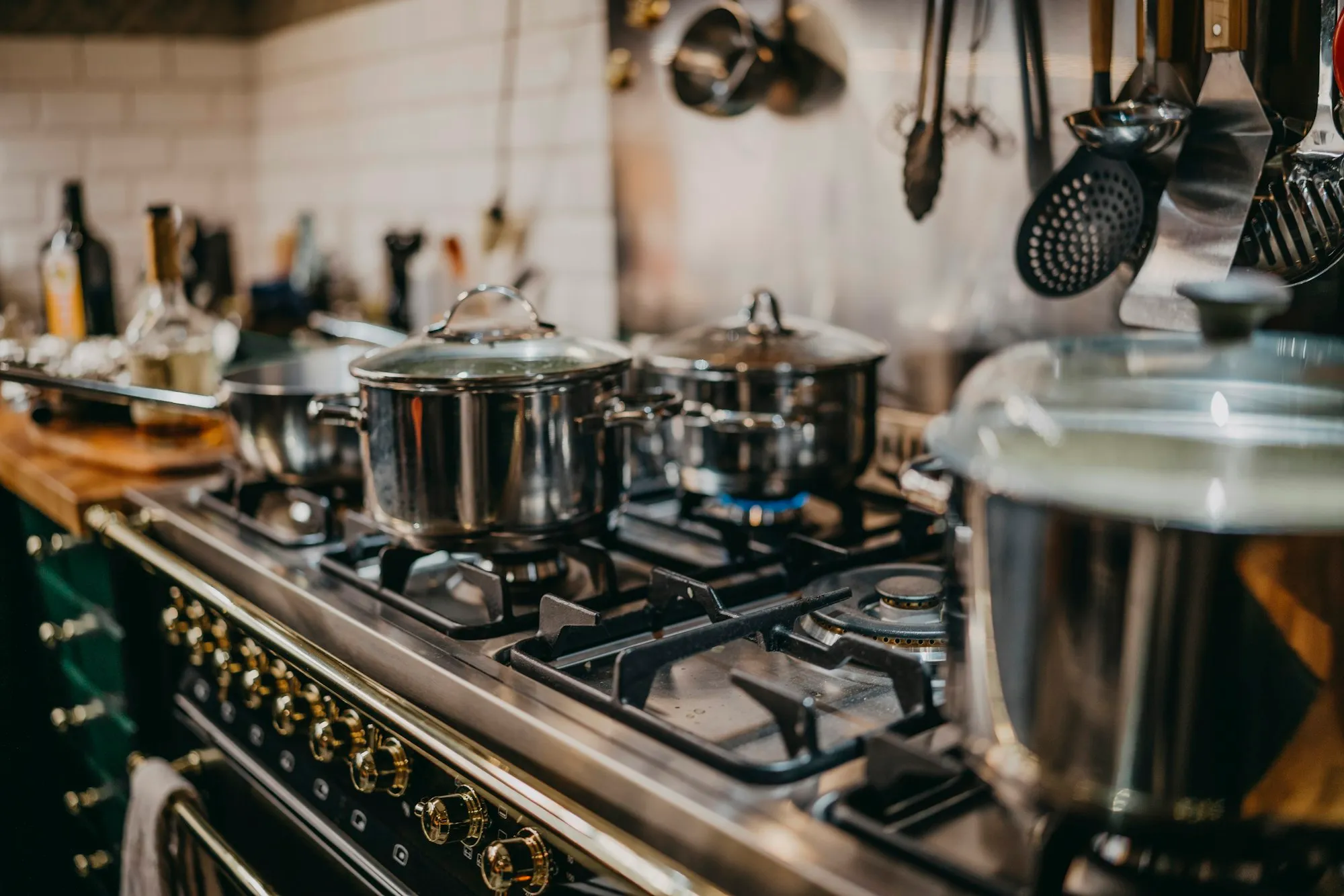 Pots on a stove and hanging kitchen tools